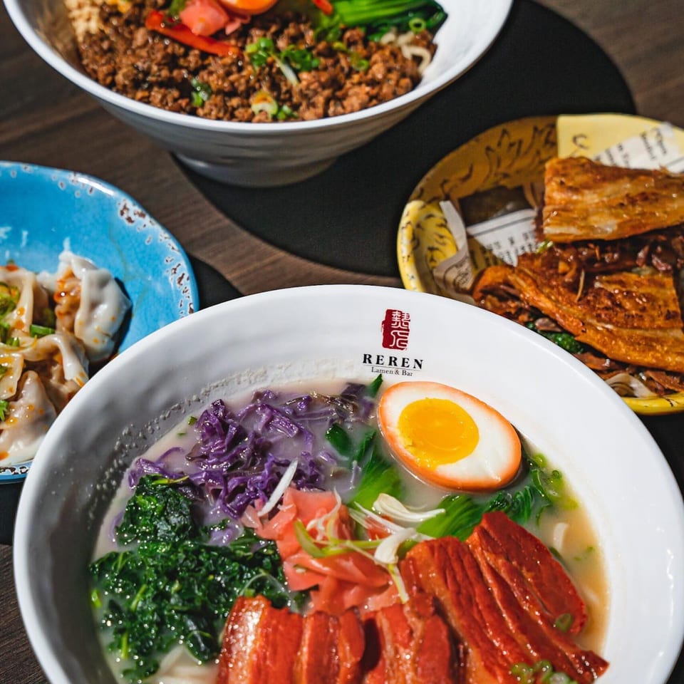 Reren Lamen & Bar's duck ramen with a soft-boiled egg, dumplings, and a bowl of spicy noodles.